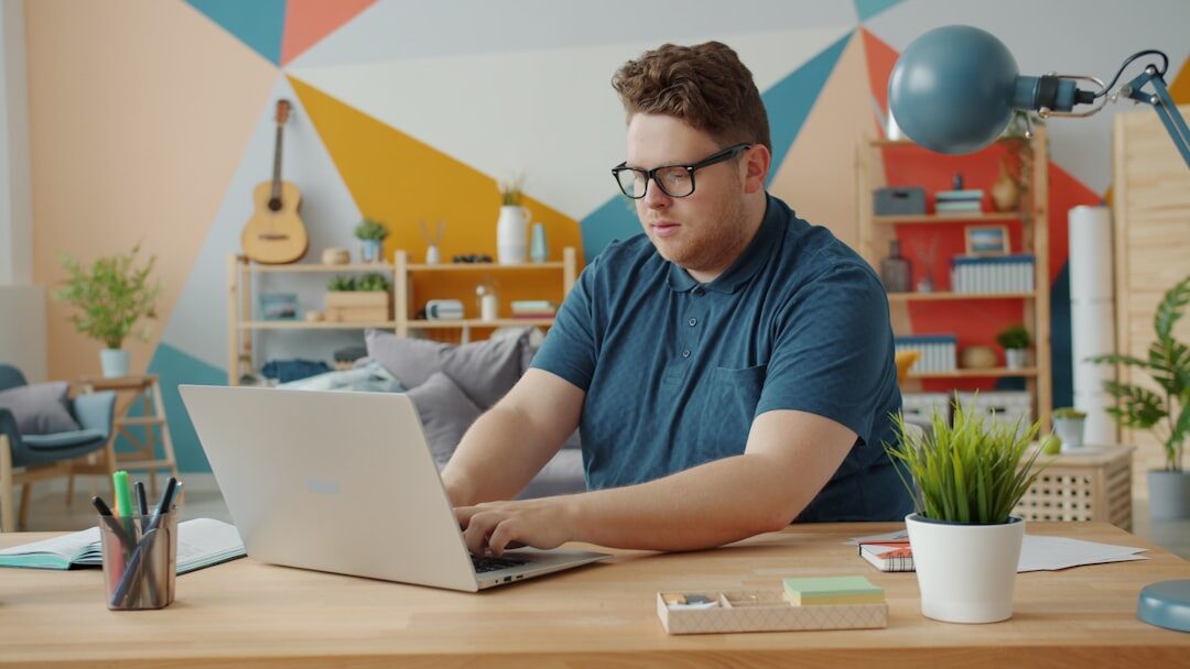 Person working remotely on laptop at home office